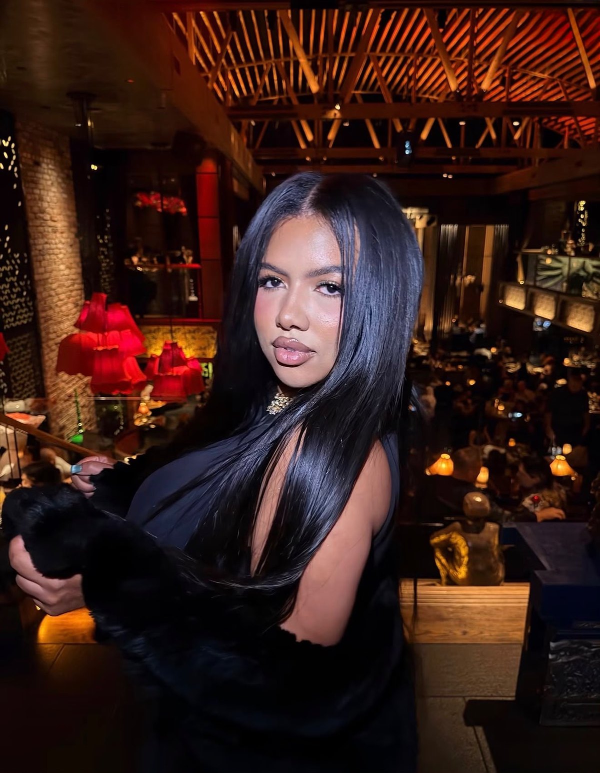 Laila with long straight black hair at a candlelit restaurant